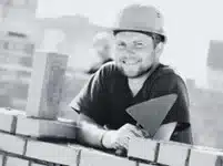 macon souriant au travail casque sur la tete tenant une true